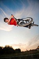Teenage boy on trials bike at a skateboard park performing aerobatic stunts, Aberystwyth Wales UK