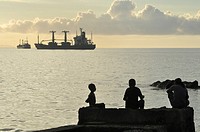 Dili (East Timor): kids at the city´s beach, near the harbor, at sunset