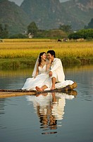 Chineses bride and groom pose for wedding photographies aboard a bamboo raft on the Yulong River, in the Yangshuo county, China.