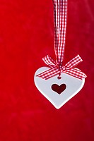 Scented ceramic heart with red and white ribbon on red background