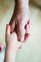 A young child shakes his grandfather´s hand