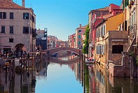 Bridge over canal in Chioggia, Italy  Typical Italian houses and gondolas