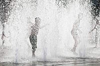 Children playing in the fountains outside the Hayward Gallery on London South Bank on a hot summer day