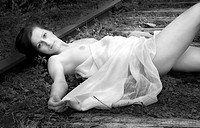 Beautiful female lying on train track