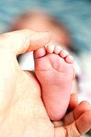 Father holding foot of baby girl