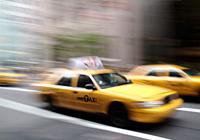 A yellow New York City taxi cab in motion in the United States of America