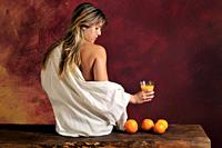 half-naked young woman witht oranges and orange juice