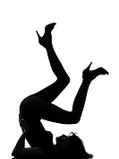 full length silhouette in shadow of a young woman floor gymnastic pike position legs in studio on white background isolated