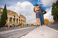 Couple kissing on the street before the Roman Colosseum in Rome Italy