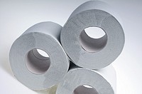 Three rolls of simple grey toilet paper made of waste paper