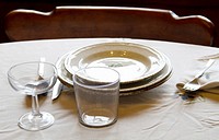 Table set with plates, cups, glasses, cover, tablecloth, spoons, forks and knives