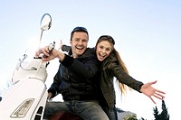Couple sitting on a motor scooter and cheering
