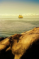 sailing ship with rocks foreground