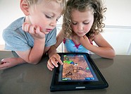 Children playing computer game on an iPad tablet computer