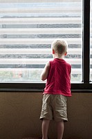A young boy looking out a high window