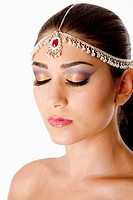 Beautiful face of a Middle Eastern woman with Arabic style makeup and head jewelry, typacally used by Indian belly dancers, isolated