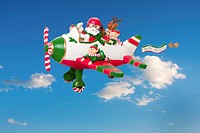Santa Claus flying his airplane with Happy Holidays banner in the sky with his elves and Rudolf the Red nosed Reindeer