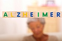 Alzheimer written in bright letters and behind, blurred the silhouette of a senior woman