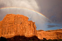 Rainbow arches above massive sandstone cliffs