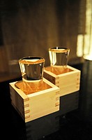 Full sake cups in wooden boxes on a table in a restaurant in Tokyo
