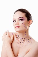 Headshot of a beautiful Caucasian woman with purple makeup and rhinestones, isolated