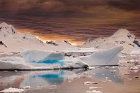 Storm clouds gather at sunset over peaks around Wiencke Island, Neumeyer Channel, Antarctic Peninsula.