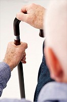 Senior man  detail  seen from behind waiting with his hand on a crutch in a clinic waiting room or medical center