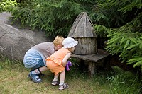 Kid Girl and Boy Looking Small Fairy-Tale House at Pokumaa, Võru County, Estonia