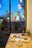 Coffee with cake for two at dusk. Independencia Square, Madrid, Spain.