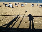 Shadows of people on the beach of Westerland, beach chairs and the North Sea in the background, Sylt, Germany