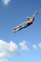 Nine year old boy swinging on a rope swing Atiamuri, New Zealand