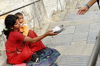 mother holding her baby whilst begging for money, the nepalis , life in kathmandu , kathmandu street life , nepal