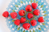 Raspberries on a colored porcelain plate