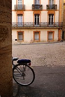 A bicycle left leaning against a wall in Pezenas, France.