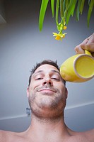 Man in his kitchen drinking coffee from a yellow mug