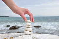 Woman stacking stones on beach