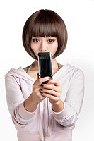Beautiful Chinese woman using a cell phone on a white background