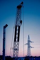 Cranes and electric tower in twilight sky