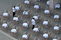 Waiters at empty cafe terrace on Piazza San Marco, elevated view from the Bell Tower, Venice, Italy