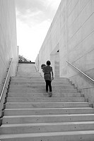 A girl rises a white stairs with a ball