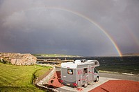 Uyeasound, Unst, Shetland Islands, Scotland, UK, Europe  Motorhome in Gardiesfauld youth hostel campsite with rainbow and grey clouds over the sea  Mo...