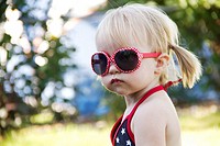 A one year old toddler wearing bright red sunglasses on Independence Day in Liberty Lake, Washington, USA.