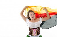 Young woman in dirndl dress cheering with Germany flag