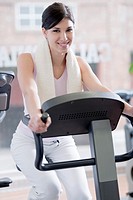 Beautiful young woman at gym, doing biking exercises