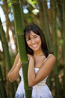 Latin woman in bamboo forest smiling at camera