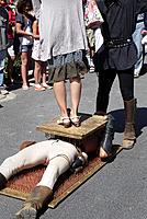 A performer at the wine festival in Fontes, France, entertains the crown by laying on a bed of nails as a woman stands on him during a street show
