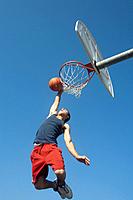 Teen jumps to dunk basketball