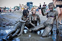 Young women having fun in the mud at the Przystanek Woodstock - Europe´s largest open air festival in Kostrzyn, Poland