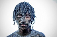young man covered in mud at the Przystanek Woodstock - Europe´s largest open air festival in Kostrzyn, Poland
