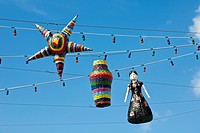 Pinatas hanging on strings of lights against blues sky in Cozumel, Mexico in the Caribbean Sea